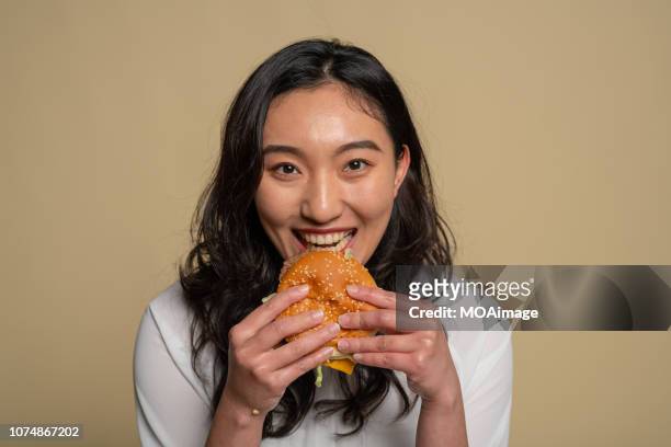 a young asian girl is eating - healthy burger stock pictures, royalty-free photos & images