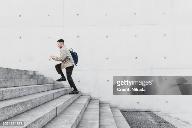 jonge man loopt trap in stedelijke omgeving - european outdoor urban walls stockfoto's en -beelden