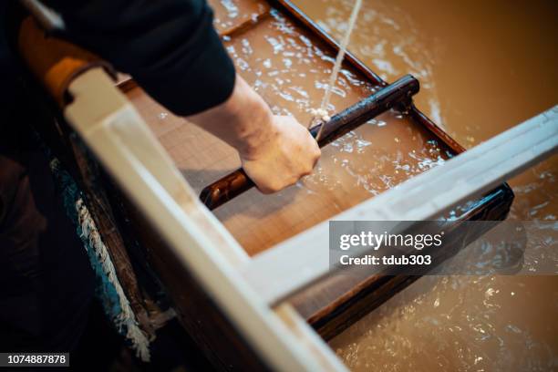 mid adult japanese man making paper using traditional methods - handmade paper stock pictures, royalty-free photos & images
