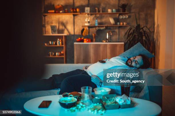 overweight guy napping - changing channels stock pictures, royalty-free photos & images