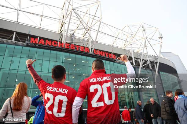 Fans pose for a photo wearing a shirt with the name of Ole Gunnar Solskjaer, Interim Manager of Manchester United as they make their way to the...