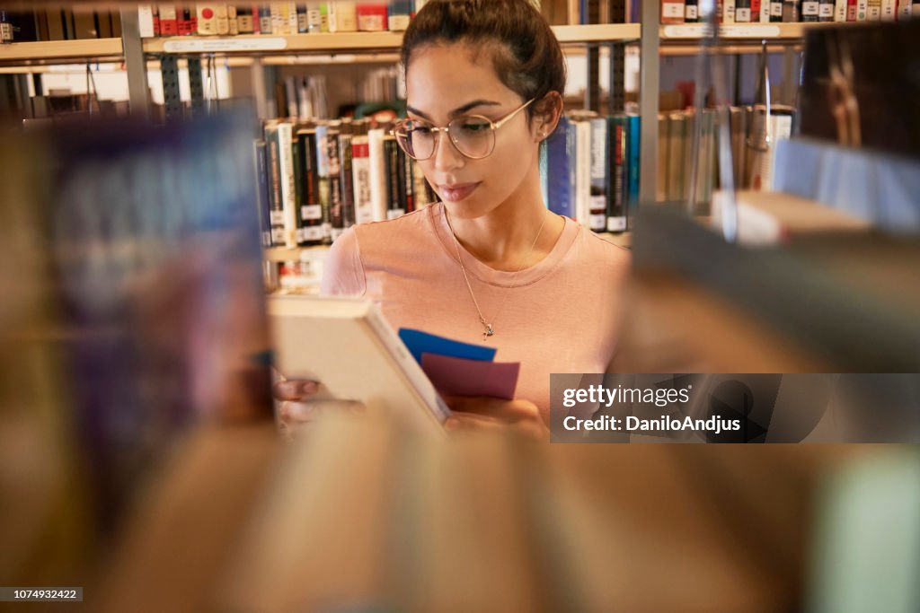 Junge Frau auf der Suche nach einem Buch