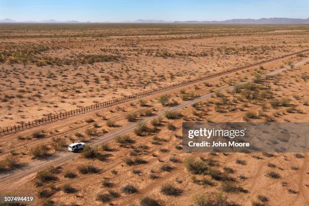 Border Patrol agents drive along the U.S.-Mexico border fence while searching for drug smugglers spotted in a remote area of the Sonoran Desert on...