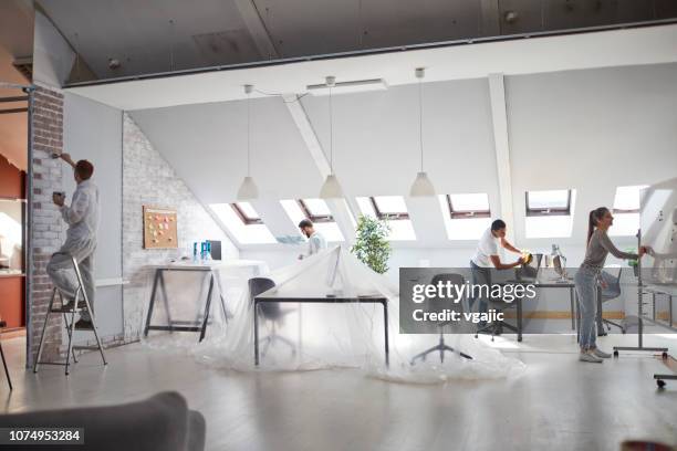 jóvenes empresarios renovar su oficina - cambio de oficina fotografías e imágenes de stock
