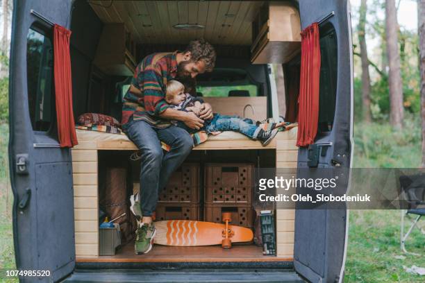 Man with son sitting in camper van