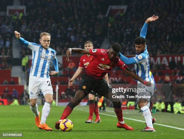 Paul Pogba of Manchester United in action with Alex Pritchard and Elias Kachunga of Huddersfield Town during the Premier League match between...