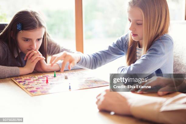 family playing board game together indoors - snakes and ladders stock pictures, royalty-free photos & images