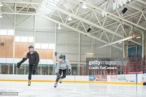 brother and sister skating - kids ice hockey stock pictures, royalty-free photos & images