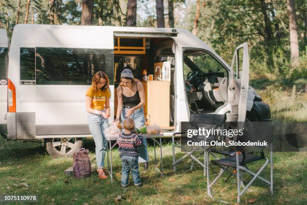 mujeres y niño cocina hamburguesas en la parrilla en el bosque - trailer fotografías e imágenes de stock