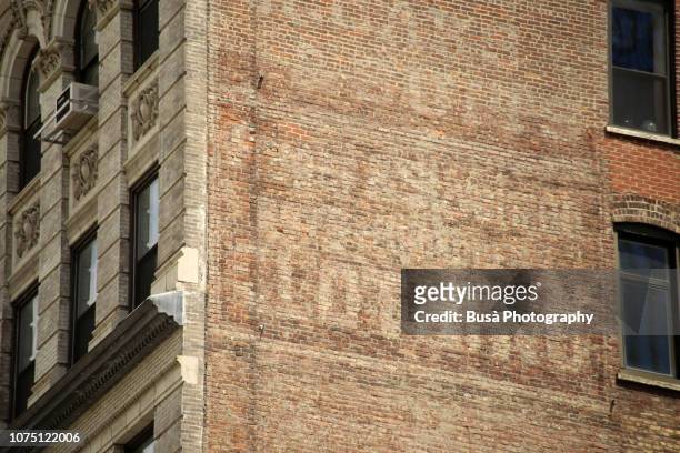 traces of old commercial mural in manhattan, new york city - brick wall stock pictures, royalty-free photos & images