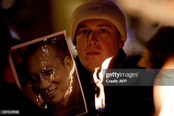 An undetified man holds a picture of dissident Liu Xiaobo during torch parade in Oslo on December 10, 2010 on the day of The Nobel Peace Prize...