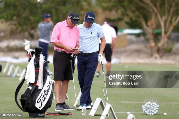 Justin Thomas of the United States looks at a video of his swing with his dad Mike Thomas while hitting balls on the range following round two of the...