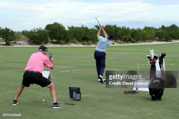 Justin Thomas of the United States works on his swing with his father Mike Thomas after the second round of the 2018 Hero World Challenge at Albany...