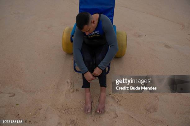 Andre Melo de Souza or Andrezinho Carioca, adapted surfer's nickname, prepares to surf at Prainha beach on December 26, 2018 in Rio de Janeiro,...