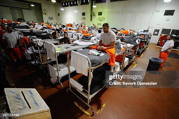 Inmates at Chino State Prison, which houses 5500 inmates, crowd around double and triple bunk beds at a gymnasium that was modified to house 213...