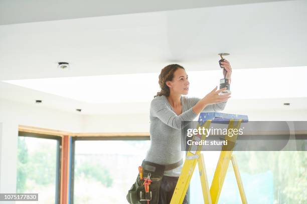female electrician installing downlights - home ceiling stock pictures, royalty-free photos & images