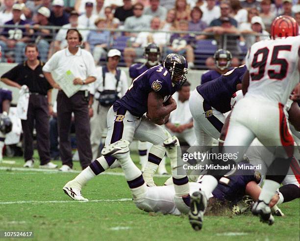 Running Back Jamal Lewis of the Baltimore Ravens carries the ball for some extra yardage upfield with the help of some good blocking by teammate...