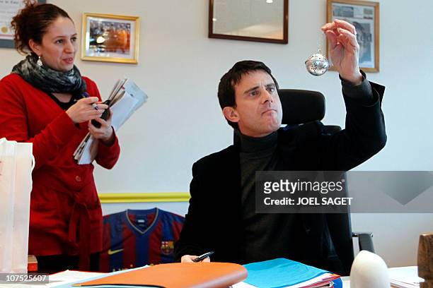 Le député-maire socialiste Manuel Valls regarde une boule de Noël qui lui a été envoyée par une de ses administrées, le 10 décembre 2010 dans son...