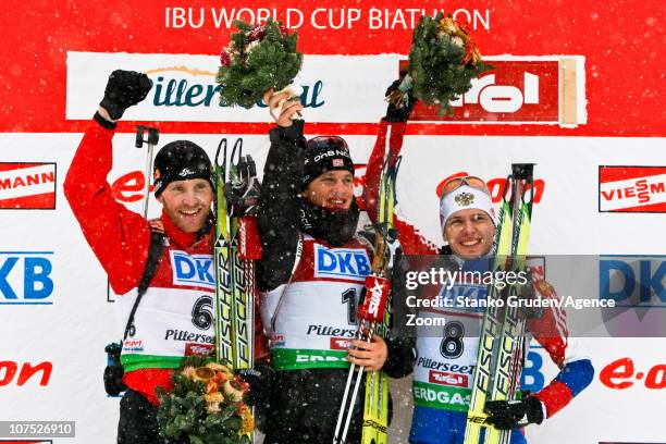 Simon Eder of Austria takes 2nd place, Tarjei Boe of Norway takes 1st place, Ivan Tcherezov of Russia takes 3rd place during the IBU World Cup...