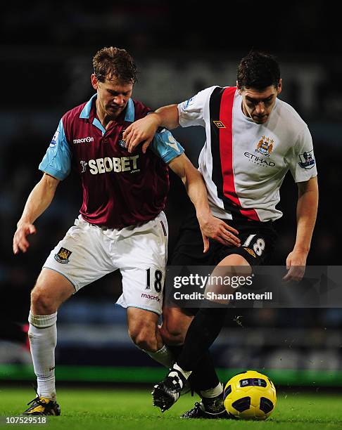 Gareth Barry of Manchester City holds off the challenge of Jonathan Spector of West Ham United during the Barclays Premier League match between West...