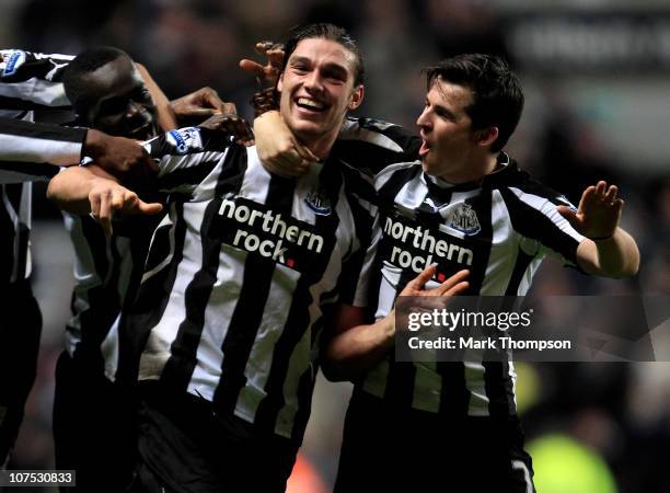 Andy Carroll of Newcastle United celebrates scoring his team's third goal with team mate Joey Barton during the Barclays Premier League match between...