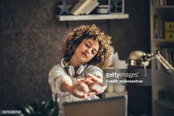 vrouw die zich uitstrekt in het kantoor - pauze stockfoto's en -beelden