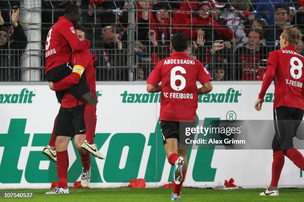 Papiss Demba Cisse of Freiburg celebrates his team's third goal with team mates Heiko Butscher, Yacine Abdessadki and Jan Rosenthal during the...