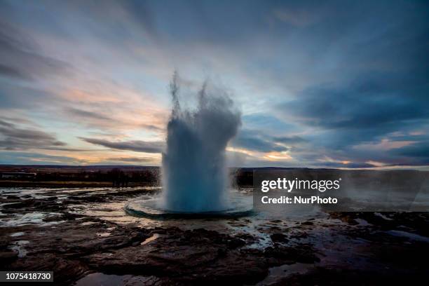 Strokkur is seen erupting, along with Geysir, The Great Geysir, seen dormant are predominate tourist destinations in southwestern Iceland as seen on...