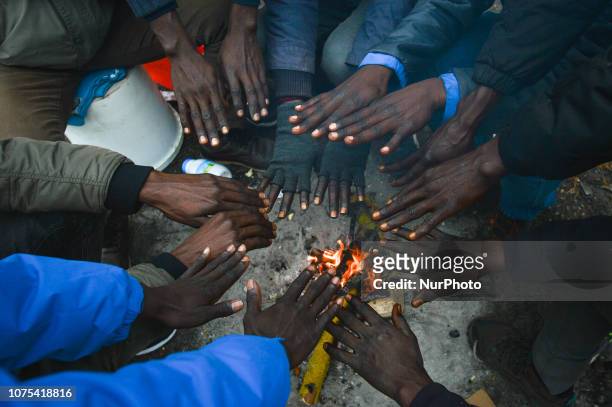 Group of Sudanese migrants seen near Ouistreham ferry terminal warming their hands over a fire. Since the beginning of December, there has been a...