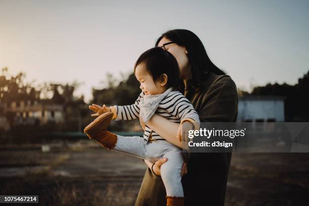 joyful mother and baby girl having fun playing in the park - zehenspitzen berühren stock-fotos und bilder