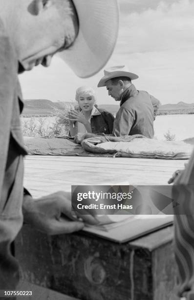 American actors Clark Gable and Marilyn Monroe during the location shoot of 'The Misfits' in the Nevada Desert, 1960. Director John Huston is in the...