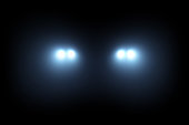 Car head lights shining from darkness background