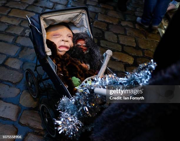 Participant pushes a pram filled with dolls as she takes part in a parade through the streets during the annual Whitby Krampus parade on December 01,...