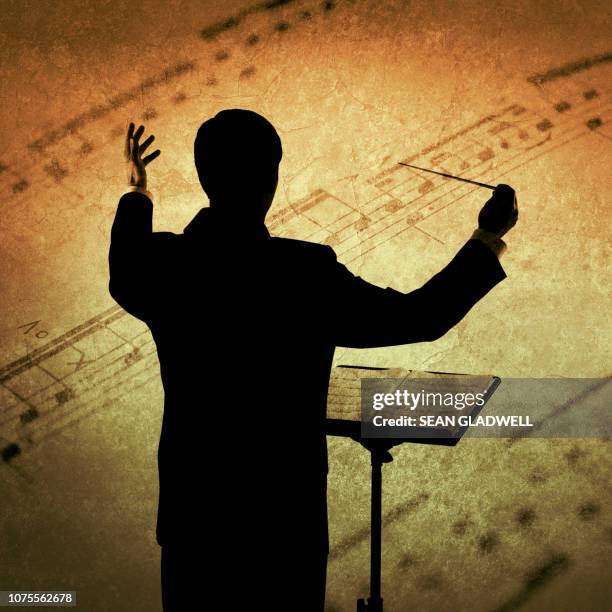 conductor and sheet music - conductor leading orchestra stock-fotos und bilder