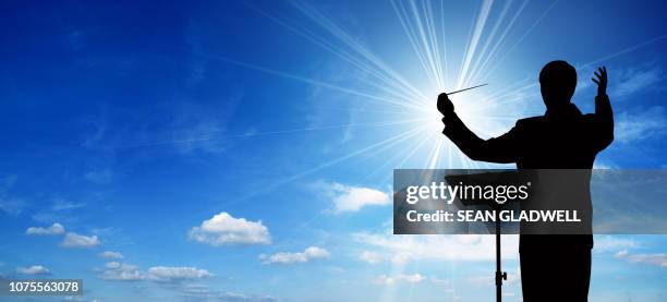 silhouette of conductor - conductor leading orchestra stock pictures, royalty-free photos & images