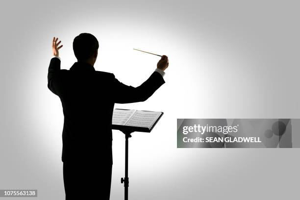 symphony conductor - conductor leading orchestra stock-fotos und bilder