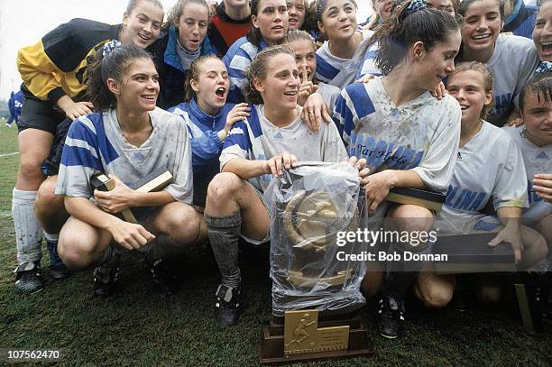 Finals: North Carolina Mia Hamm and team victorious with Championship trophy after winning game vs Duke. Weather, mud and rain.Chapel Hill, NC...