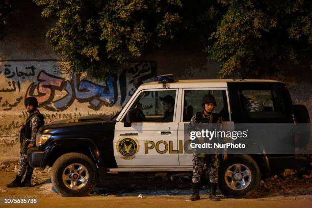 Security forces stand near a tourist bus after a roadside bomb in an area near the Giza Pyramids in Cairo, Egypt, Friday, Dec. 28, 2018. Egypt's...