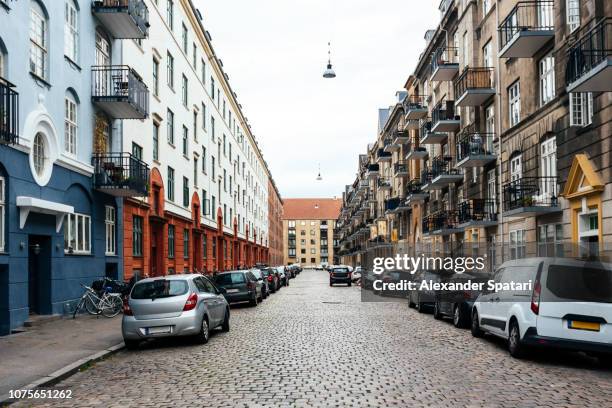 residential street in copenhagen with cars parked along the road - copenhagen park stock pictures, royalty-free photos & images