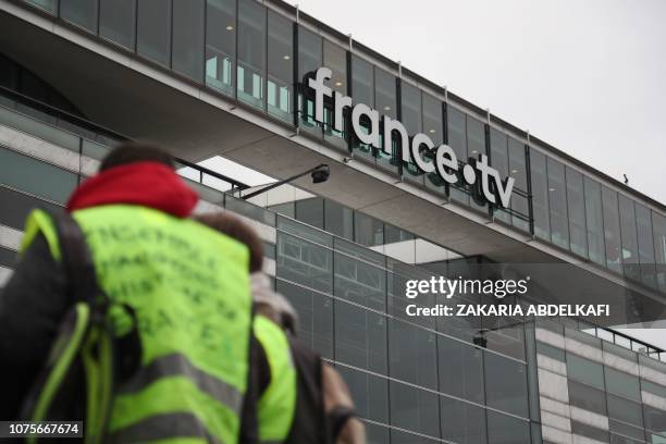 Protestors wearing yellow vests gather in fromt of the headquarters of French TV group France Television, on December 29 in Paris during a...