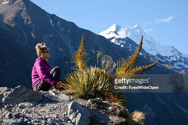 Female tourist at Tasman Glacier Lake with Mt.Cook in the background on December 12, 2010 in Aoraki / Mount Cook National Park, South Island New...