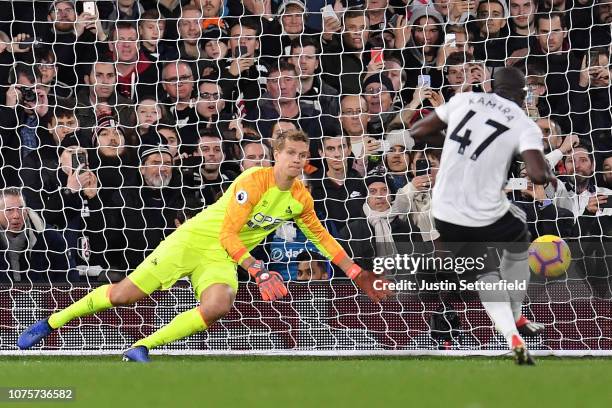 Jonas Lossl of Huddersfield Town saves the penalty taken by Aboubakar Kamara of Fulham during the Premier League match between Fulham FC and...