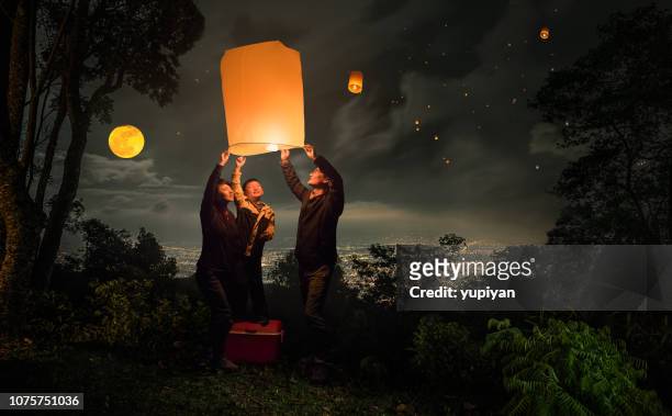 lanterna volante di famiglia nel festival loy krathong - candela attrezzatura per illuminazione foto e immagini stock