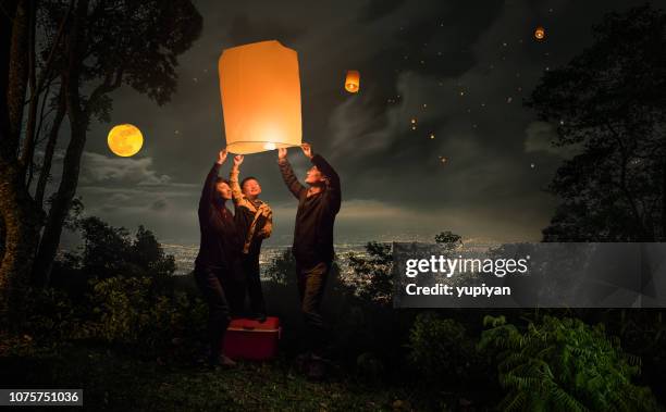 lanterna de voo família loy krathong festival - yi peng - fotografias e filmes do acervo