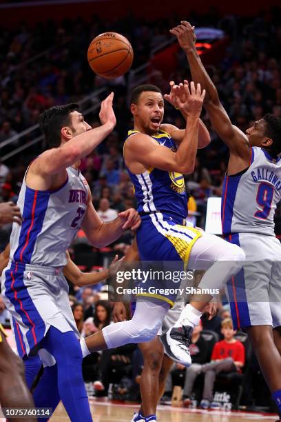 Stephen Curry of the Golden State Warriors passes from between the defense of Langston Galloway and Zaza Pachulia of the Detroit Pistons during the...