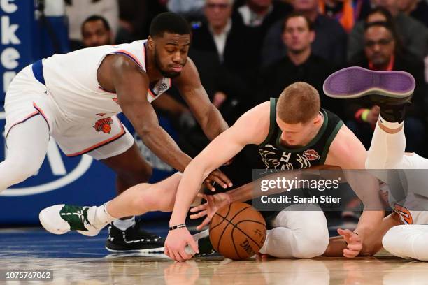 Donte DiVincenzo of the Milwaukee Bucks, Emmanuel Mudiay of the New York Knicks, and Kevin Knox of the New York Knicks fight for a loose ball during...