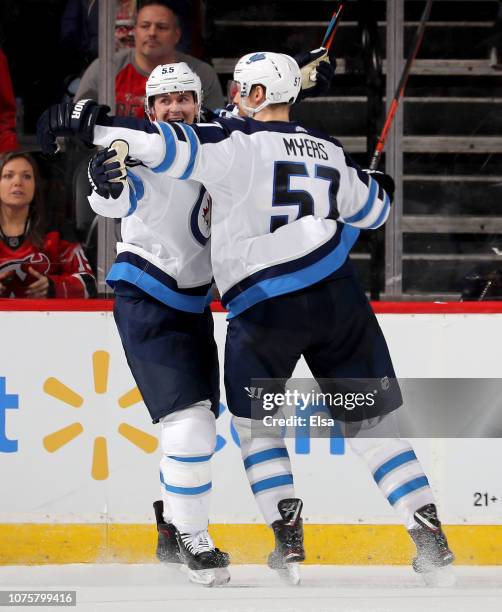 Mark Scheifele of the Winnipeg Jets celebrates his game winning goal with teamamte Tyler Myers in overtime against the New Jersey Devils at...