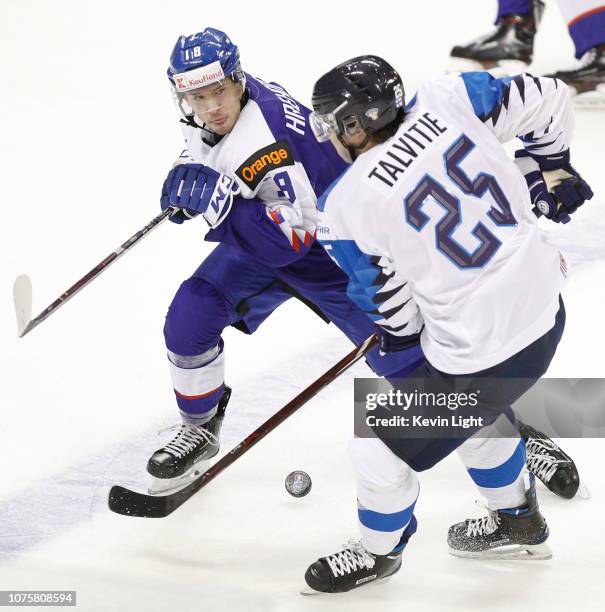 Aarne Talvitie of Finland skates with the puck while being checked by Patrik Hrehorcak of Slovakia at the IIHF World Junior Championships at the...