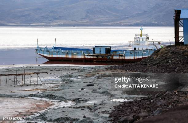 This picture taken on December 8, 2018 shows a view of a ship moored by the shore of Iran's salt lake of Urmia in the country's northwest, which had...