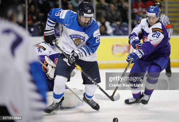 Anton Lundell of Finland skates with the puck while being checked by Ivan Michal of Slovakia at the IIHF World Junior Championships at the...
